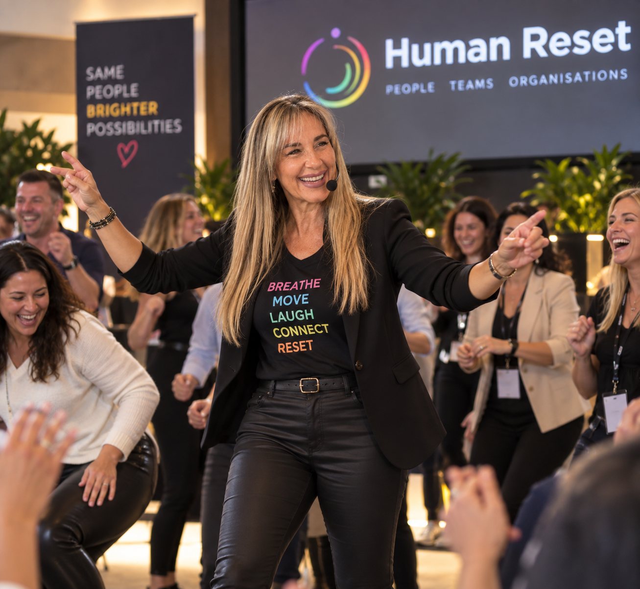 Shareen Richter with arms raised as delegates join in during a Human Reset session